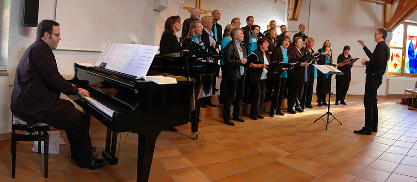 Pianist und Chor beim Auftritt in einem Gemeindesaal